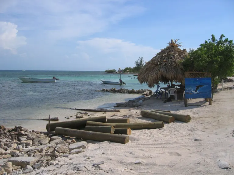 Playa con palapa y lanchas en la isla de Utila, Honduras